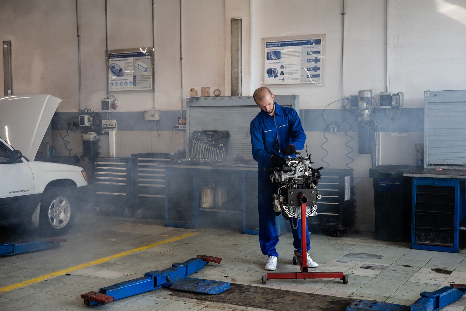 Mechanik pracujący przy silniku samochodowym w warsztacie